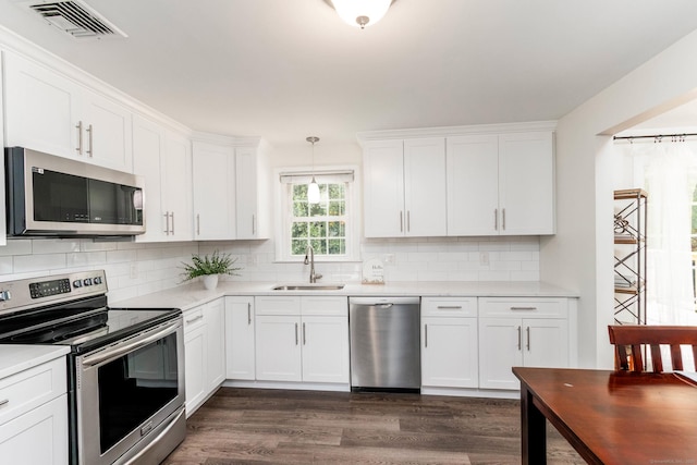 26 Sharon Cir, Meriden, CT 06450 - kitchen featuring appliances with stainless steel finishes, light countertops, dark wood finished floors, and white cabinetry