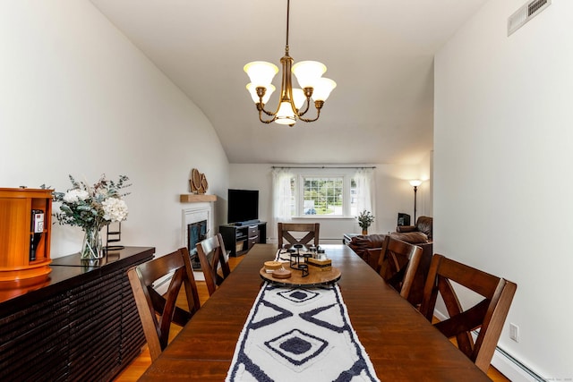 26 Sharon Cir, Meriden, CT 06450 - dining space with baseboard heating, lofted ceiling, a fireplace, a chandelier, and wood finished floors