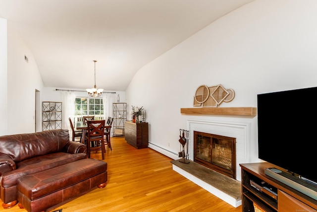 26 Sharon Cir, Meriden, CT 06450 - living area with lofted ceiling, light wood-style floors, a chandelier, a baseboard radiator, and a glass covered fireplace