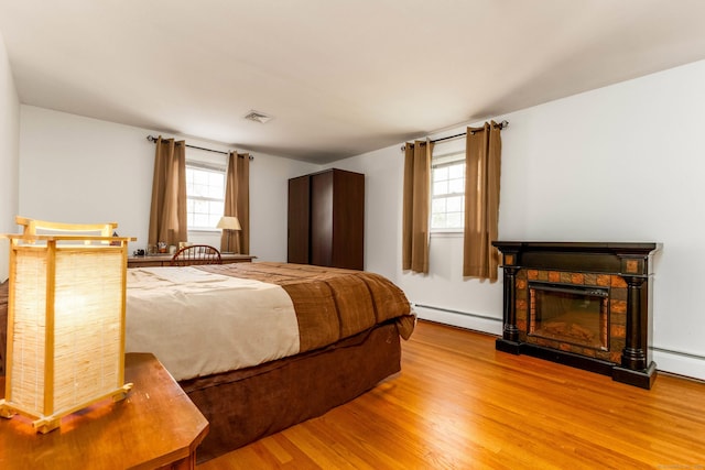 26 Sharon Cir, Meriden, CT 06450 - bedroom featuring a baseboard radiator, wood finished floors, multiple windows, and a fireplace