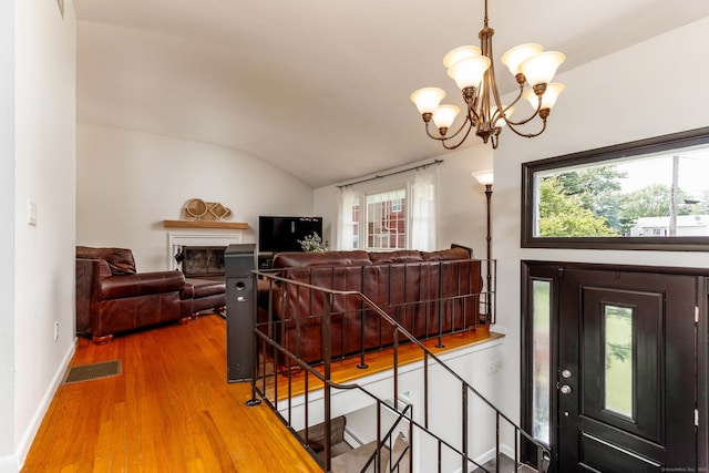 26 Sharon Cir, Meriden, CT 06450 - foyer entrance with wood finished floors, vaulted ceiling, a chandelier, and a fireplace
