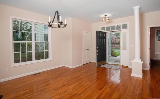 entryway with baseboards, a chandelier, wood finished floors, and visible vents