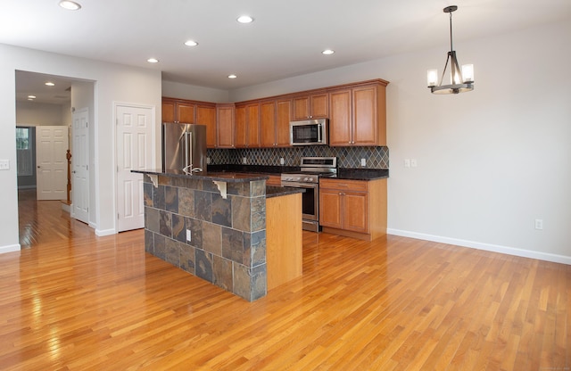 kitchen featuring light wood finished floors, appliances with stainless steel finishes, and recessed lighting