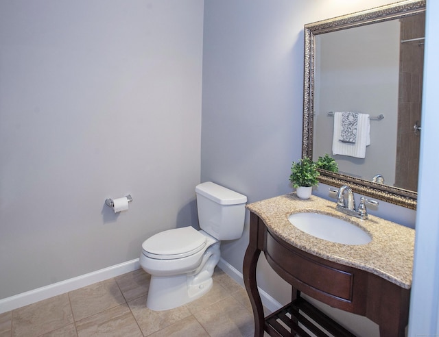 bathroom featuring toilet, baseboards, vanity, and tile patterned flooring