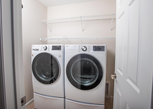 laundry room with tile patterned floors, independent washer and dryer, baseboards, and laundry area
