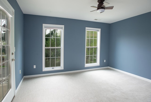 unfurnished room with a wealth of natural light, baseboards, and visible vents