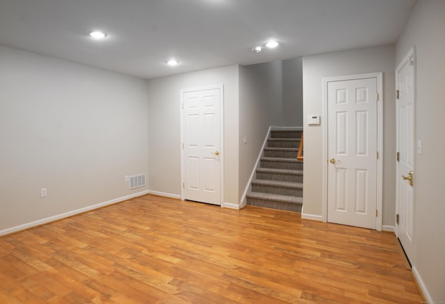 basement with recessed lighting, baseboards, visible vents, stairs, and light wood-style floors