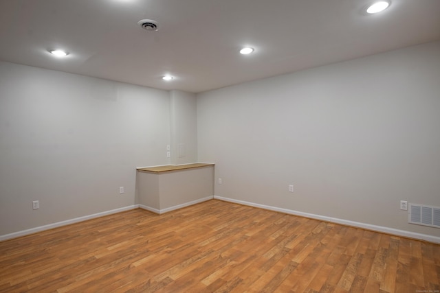 empty room featuring baseboards, light wood-type flooring, visible vents, and recessed lighting