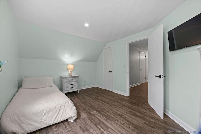 bedroom featuring vaulted ceiling, baseboards, and wood finished floors