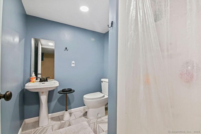 bathroom featuring baseboards, toilet, and a shower with shower curtain