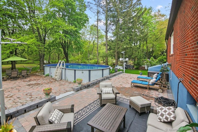 view of patio featuring an outdoor living space, an outdoor pool, view of scattered trees, and outdoor dining area