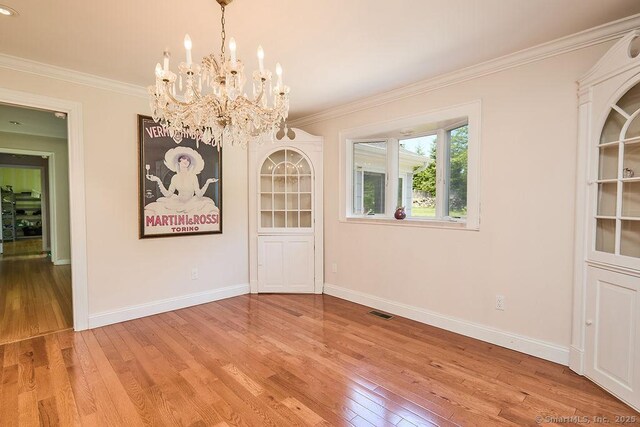 17 Grays Farm Rd, Weston, CT 06883 - unfurnished dining area with a chandelier, ornamental molding, light wood-style flooring, and baseboards