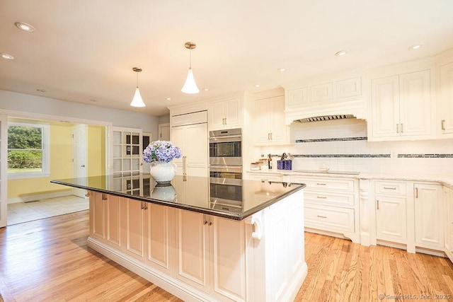 17 Grays Farm Rd, Weston, CT 06883 - kitchen featuring double oven, light wood finished floors, a kitchen island, decorative backsplash, and black electric stovetop