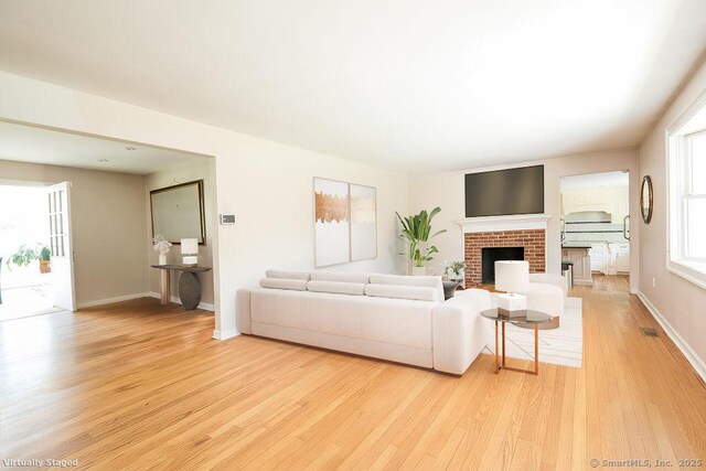 17 Grays Farm Rd, Weston, CT 06883 - living room featuring light wood-style flooring, a brick fireplace, and baseboards