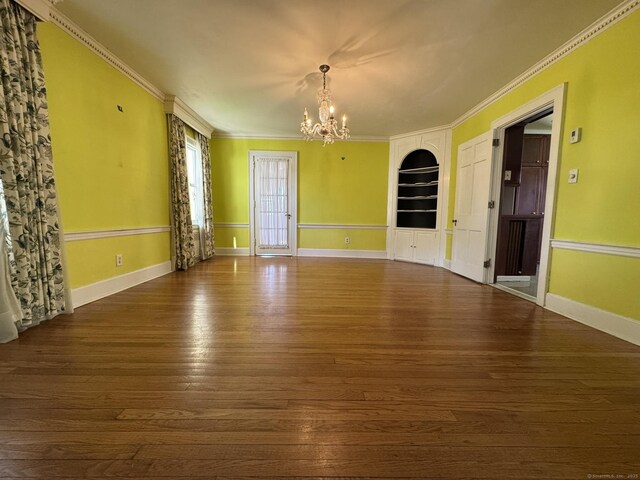 135 Lambert Ave, Meriden, CT 06451 - spare room with a chandelier, wood finished floors, built in shelves, crown molding, and baseboards