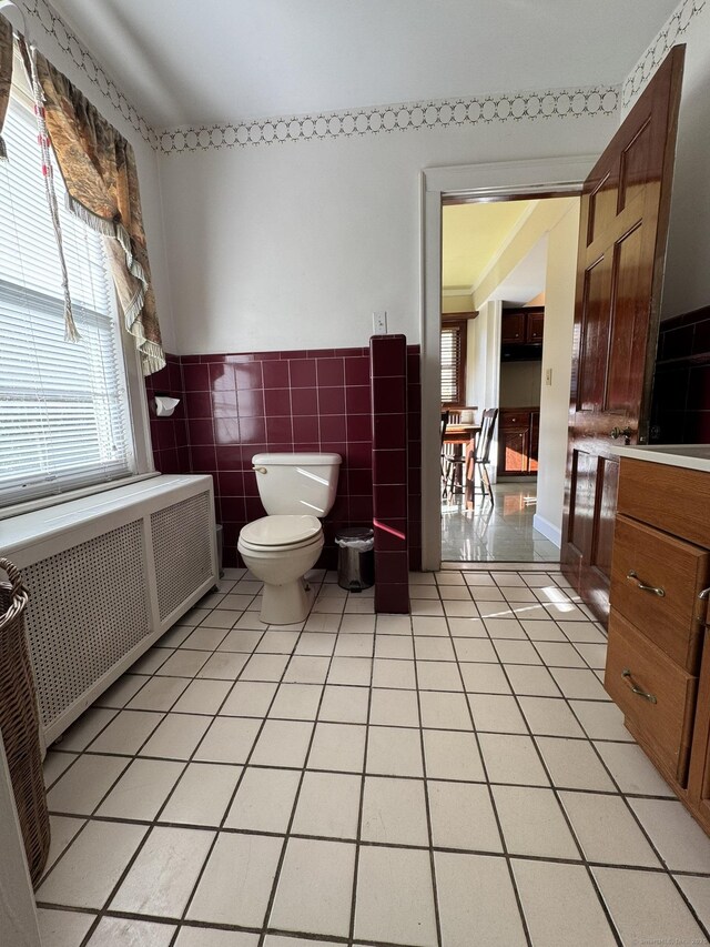 135 Lambert Ave, Meriden, CT 06451 - bathroom featuring radiator heating unit, tile patterned floors, toilet, tile walls, and a wainscoted wall