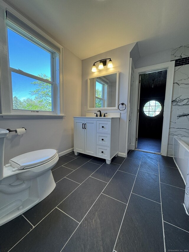 135 Lambert Ave, Meriden, CT 06451 - full bath featuring baseboards, vanity, toilet, tile patterned floors, and a tub to relax in