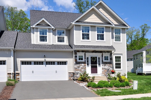 craftsman house with driveway, a garage, stone siding, and roof with shingles