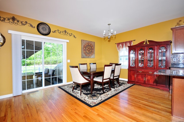 dining space with wood finished floors, a chandelier, and baseboards