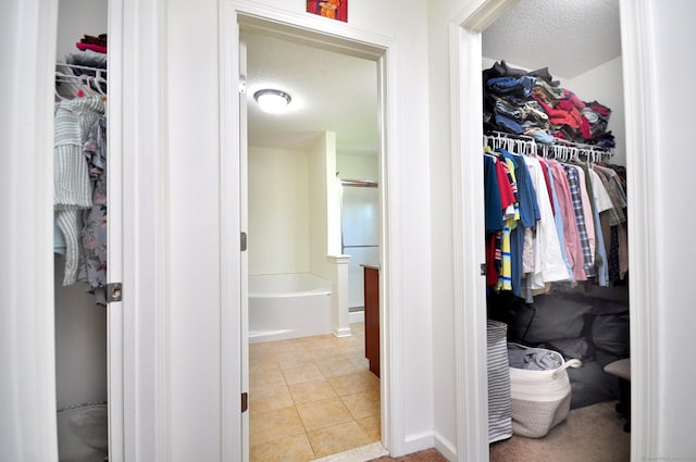 walk in closet with light tile patterned floors