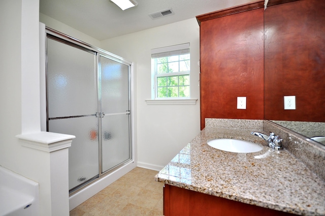 full bath with a stall shower, vanity, and baseboards