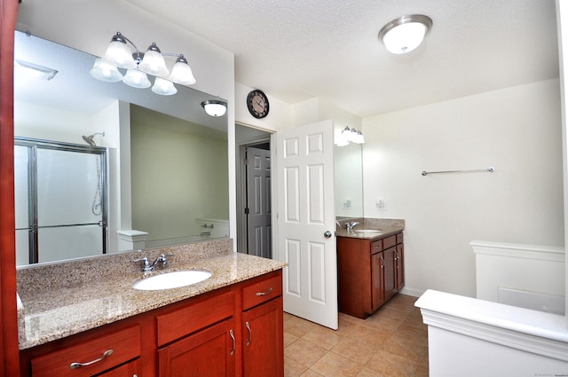 full bath featuring a shower stall, toilet, tile patterned flooring, and two vanities