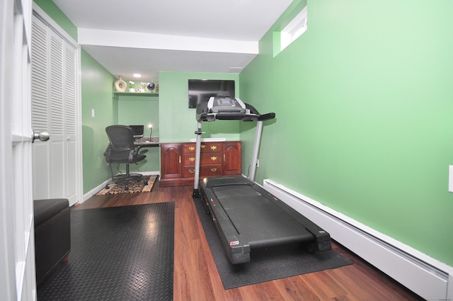workout room featuring baseboard heating, wood finished floors, and baseboards