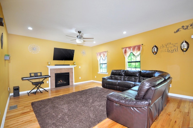 living room with wood finished floors, a ceiling fan, a fireplace, baseboards, and recessed lighting