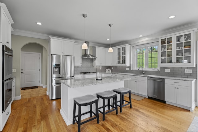 20 Peach Ln, East Lyme, CT 06333 - kitchen with stainless steel appliances, wall chimney exhaust hood, crown molding, a sink, and white cabinetry