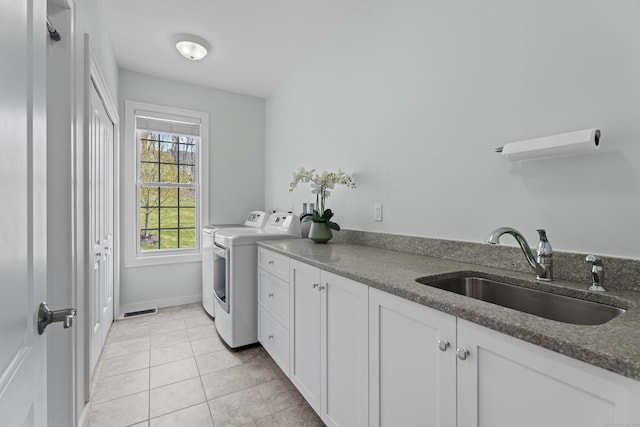 20 Peach Ln, East Lyme, CT 06333 - laundry area featuring separate washer and dryer, cabinet space, light tile patterned floors, and baseboards
