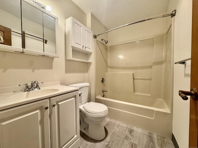 full bath featuring a textured ceiling, toilet, vanity, wood finished floors, and bathing tub / shower combination