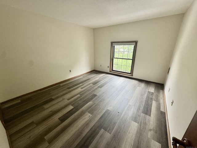 spare room with wood finished floors and baseboards