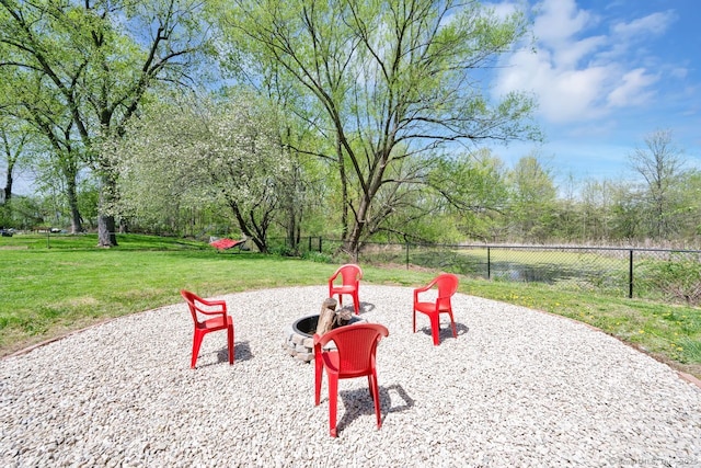exterior space with a lawn, a fire pit, and fence