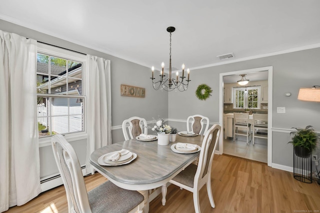 dining area with visible vents, light wood-style flooring, a healthy amount of sunlight, and a notable chandelier