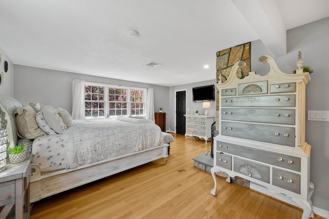 bedroom with visible vents and wood finished floors
