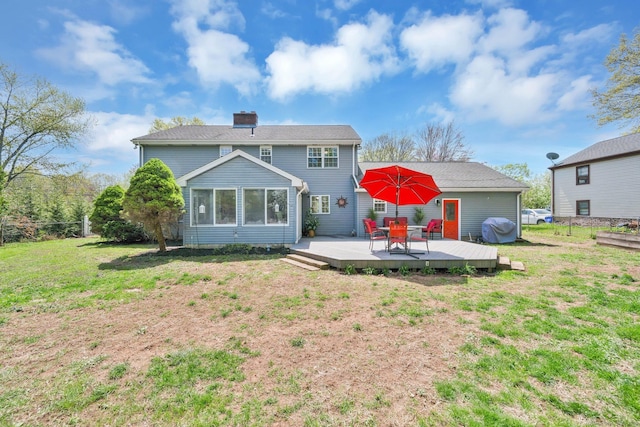 rear view of property featuring a wooden deck, a sunroom, a chimney, and a lawn