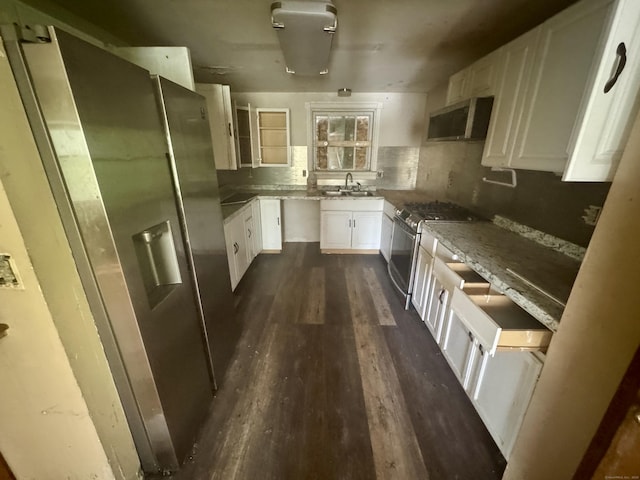 kitchen featuring a sink, wall chimney exhaust hood, dark wood-style flooring, white cabinetry, and appliances with stainless steel finishes