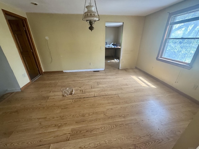 unfurnished dining area featuring light wood-style floors and baseboards
