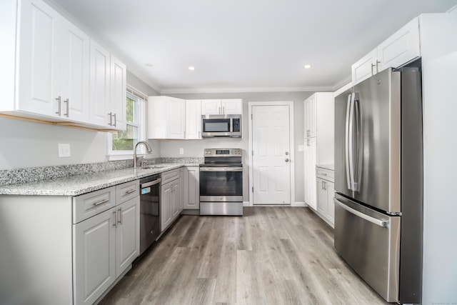 17 Alan Ave, Danbury, CT 06811 - kitchen with appliances with stainless steel finishes, a sink, light wood-style flooring, ornamental molding, and white cabinetry