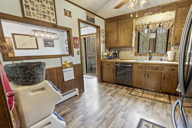 kitchen featuring a sink, a baseboard heating unit, dishwashing machine, light countertops, and light wood-style floors