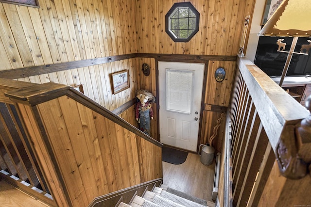 stairway with wood walls and wood finished floors