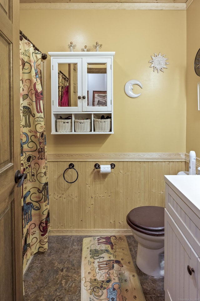 full bath with toilet, curtained shower, wainscoting, and vanity