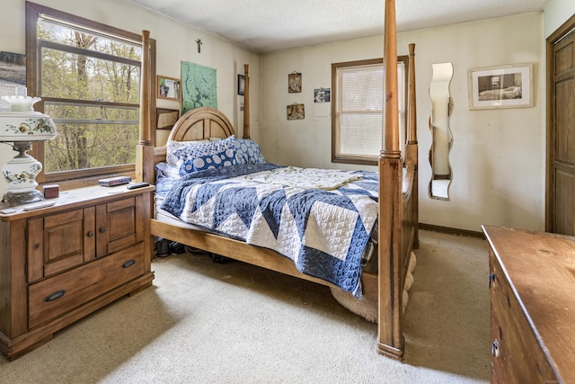 bedroom with light colored carpet and a textured ceiling