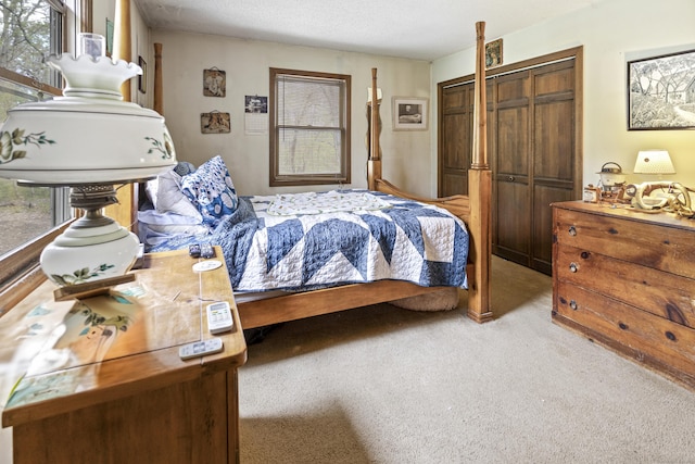 bedroom featuring light colored carpet, a closet, and a textured ceiling