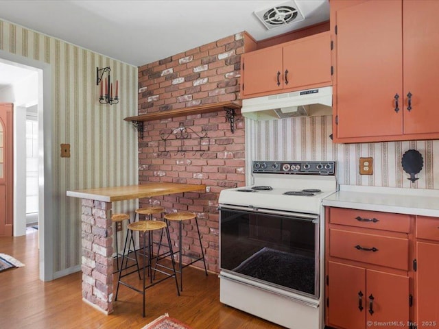 23 Pine Woods Rd, North Stonington, CT 06359 - kitchen featuring electric stove, under cabinet range hood, wallpapered walls, light wood finished floors, and light countertops