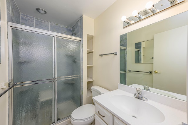 bathroom with a shower stall, toilet, and vanity