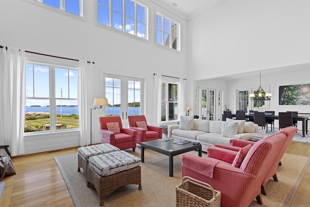 250 Joshua Point Rd, Guilford, CT 06437 - living room with light wood-style flooring, plenty of natural light, a chandelier, a towering ceiling, and crown molding
