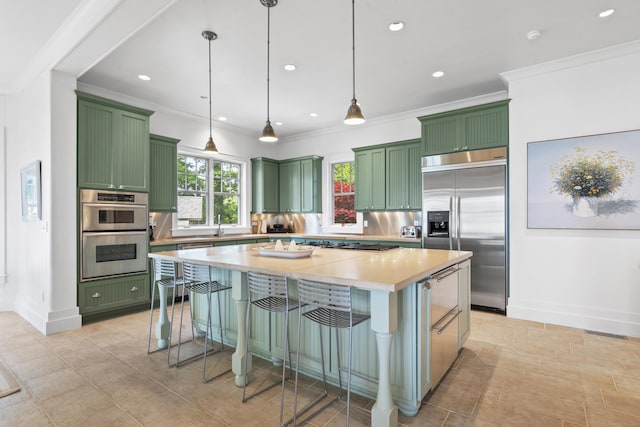 250 Joshua Point Rd, Guilford, CT 06437 - kitchen with green cabinetry, stainless steel appliances, light countertops, baseboards, and a breakfast bar area