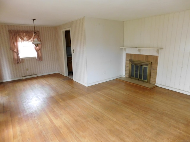 42 Riverside Dr, Branford, CT 06405 - unfurnished living room with wallpapered walls, a baseboard heating unit, baseboards, a brick fireplace, and light wood-style floors
