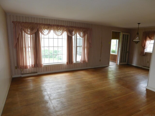 42 Riverside Dr, Branford, CT 06405 - spare room featuring a baseboard radiator, baseboards, wallpapered walls, and wood finished floors